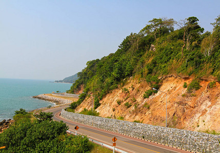 蓝天绿植山的海沙滩弯道景观之美与交通理念图片