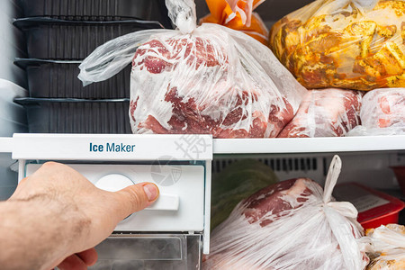 一个人打开一个冷冻食物的冰柜来图片