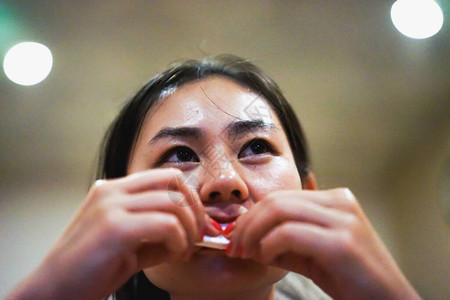 年轻快乐微笑的亚洲女孩在餐厅吃完食物后擦嘴图片