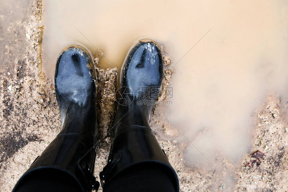 站在泥泞中的黑色靴子图片