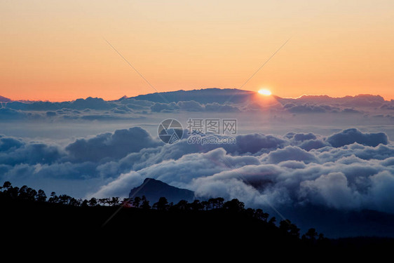 Tenerife公园日落太阳在地平线上的云层上落下图片