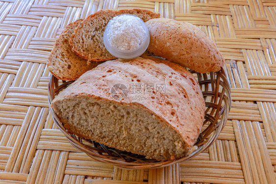 由小麦和黑麦面粉制成的新鲜自制面包用柳条筐切好的面包碗加盐柳条篮中的美味自制糕点竹背景图片