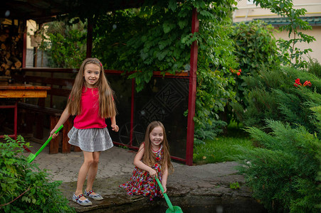 两个可爱的小女孩在炎热和阳光明媚的夏日玩城市喷泉两个夏天的小女孩在街上玩耍小时候啊姐妹们5岁和6岁的儿童图片