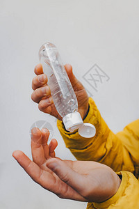 儿童手中的凝胶瓶防止细菌防腐处理酒精的组成黄色夹克图片