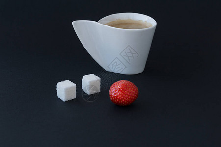 白杯咖啡两片糖和黑色背景上的小草莓背景图片