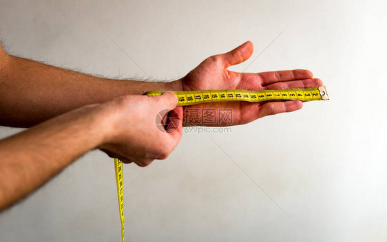 用黄色胶带测量他的左手从指到手腕图片