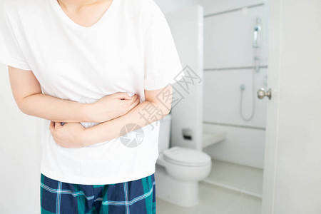 年轻女在家里的厕所前遭受腹痛腹痛的原因包括腹泻便秘中毒月经痛或肠易激图片