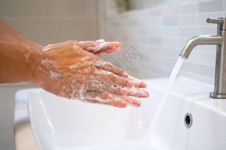 女使用凝胶洗手并打开水洗手是目前在世界范围内传播的感染或图片