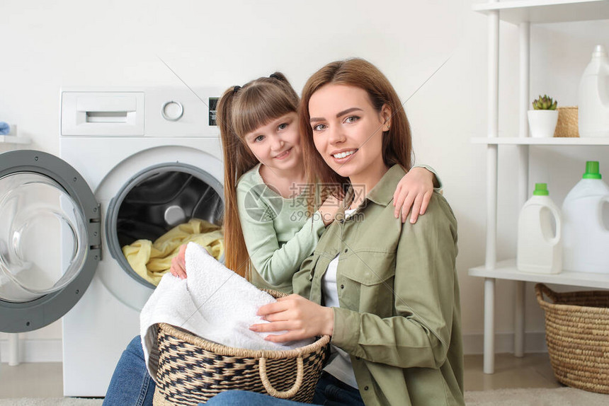 女人和她可爱的小女儿在家洗衣服图片