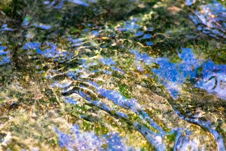 水晶般清澈的小溪水中柔滑的涟漪图片
