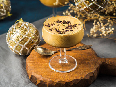 舒芙蕾甜品Frappe在甜点上冻冷咖啡饮料褐色木板上的棕色墨镜圣诞甜品概念与节背景