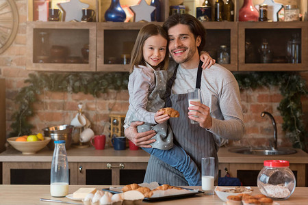 快乐的年轻爸和小女儿享受新鲜的家庭糕点图片