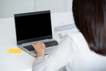 利用办公室黑屏的笔记本电脑对商业妇女进行回视背景图片