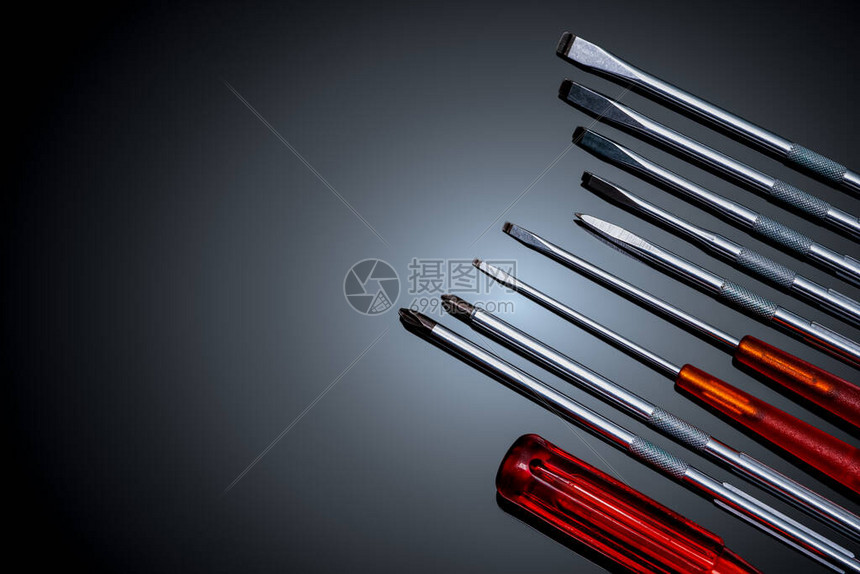 螺丝刀和中心冲头机械手工具带可互换刀片的螺丝刀套装移动工具集在黑色背景上设置的工具带橙色手柄的螺丝图片