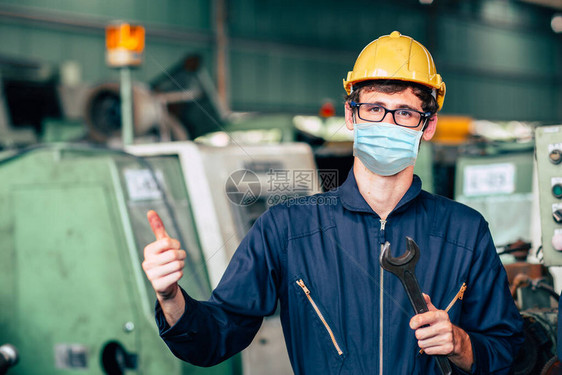 美国青年工人佩戴一次面罩或HEPA防护盾图片