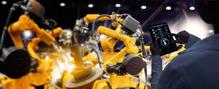 工厂女工业程师在智能工厂业中使用自动化机器人手臂机器进行实时监控系统软件背景图片