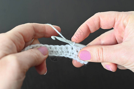 用钩针编织的女人的手细节图片