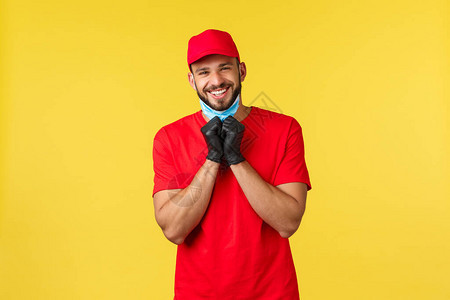 大流行期间的快递covid19安全运输在线购物概念身穿红色制服手套摘下医用面具真诚微笑黄色背景的图片