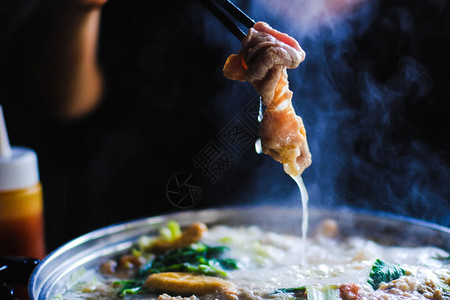用筷子夹着牛肉片的女人涮锅是韩国或日本风格的牛肉图片