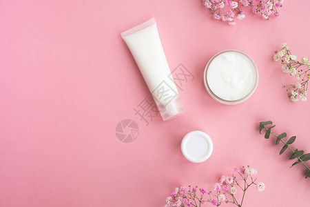 淡粉色背景上的化妆品鲜花和桉树叶概念天然化妆品美容护肤顶视图平图片