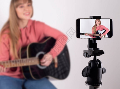 女孩弹吉他在社交网络上分享将社交媒体影响者的概念用图片