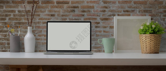 用模拟笔记本电脑杯子画刷和白色桌子上的装饰品背景图片