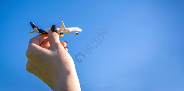 孩子手中的高平面白色玩具在阳光明媚的天空中飞翔图片
