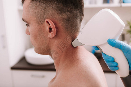 一名男子在美容诊所接受激光除发治疗的裁剪镜头图片