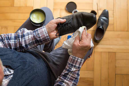 男人用抹布和鞋蜡毛巾洗鞋的手他的图片