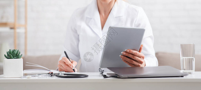现代在线记录可以看医生穿白色制服手拿着平板电脑的妇女会做笔记图片