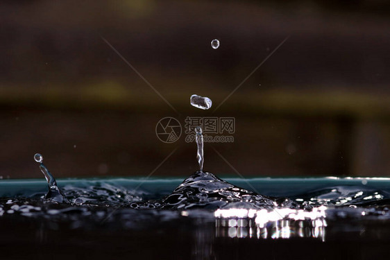 大雨滴落入水桶图片