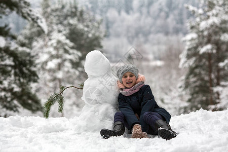 可爱的小女孩在冬季雪地公园和雪图片