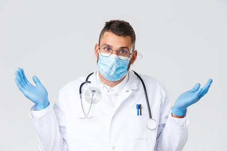 犹豫不决和不确定的西班牙裔医生戴着医用口罩和手套图片