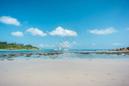塞舌尔LaDiguue岛AnseCoco海滩上的海洋浪白船原始蓝色环礁湖图片