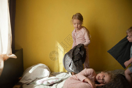 孩子们在父母的床上玩耍孩子们在父母卧室的床上跑来去枕头大战图片