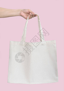 手提袋帆布白色棉织物布生态肩购物袋样机空白模板隔离在柔和的粉红色背景图片