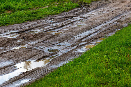 有水坑和轮胎痕迹的肮脏的粘土泥路背景图片