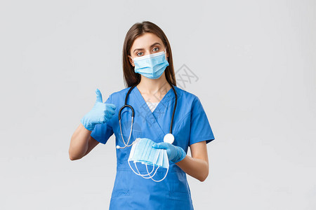 身穿蓝色磨砂服和个人防护设备的专业女护士或医生图片