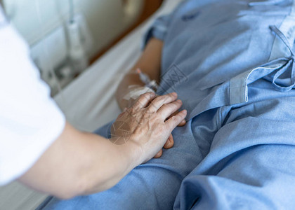 与家庭护理人员或护理人员一起躺在医院病床上图片