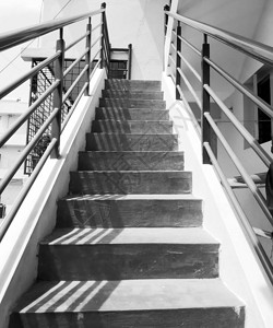 黑色和白色外门水泥楼梯与钢铁扶手的钢铁栅栏接上图片