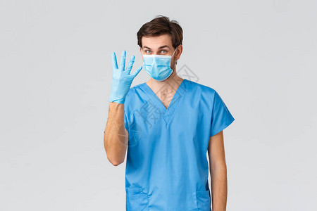 身穿蓝色磨砂医用口罩和手套的年轻医生或医生图片