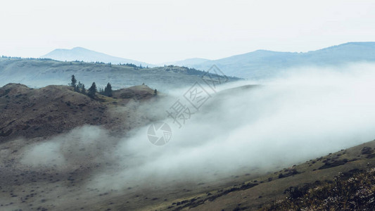 山谷有雾的早晨云雾缭绕的地平线上的岩脊背景图片