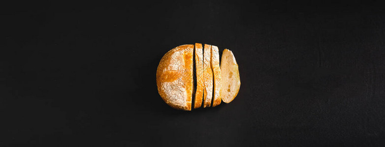黑色背景的一小包新鲜烤面包图片