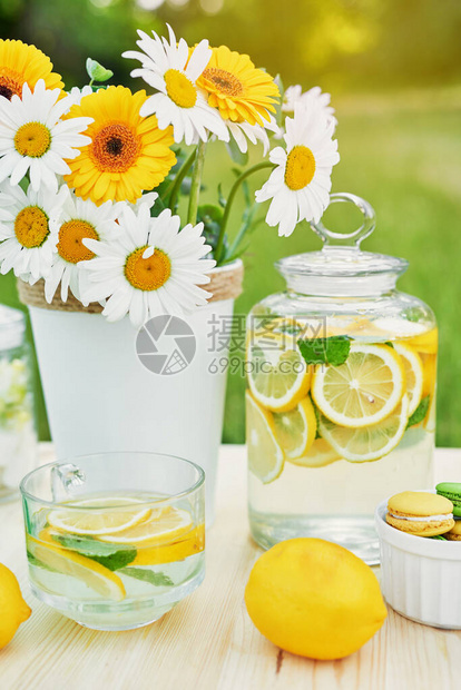 柠檬水和雏菊花在桌子上梅森罐玻璃柠檬水舒适的早晨春季和夏季节卡健康食品和饮料暑假户外野餐图片