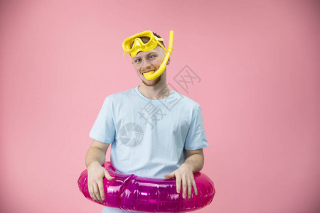 一个戴着黄色游泳面具嘴里叼着游泳管腰带上系着橡胶圈的年轻人图片
