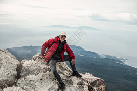 男人穿着温暖的衣服白天在岩石海图片