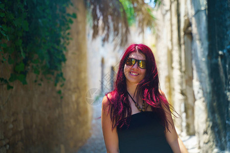 快乐的女旅行者在阳光明媚的日子行走并探索希腊罗兹岛多德图片