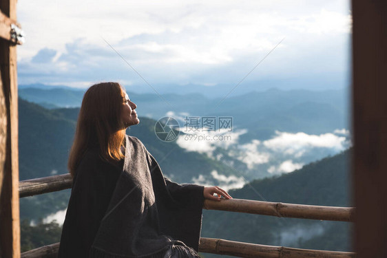 一个女人独自站在阳台上早上在蓝天背图片