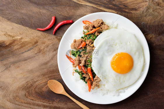 盘上泰国食物炸炒鸡肉和煎蛋PadKapraoMooKaa图片