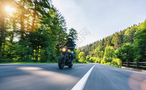 高山公路上骑摩托车在摩托车之旅中驾驶空荡的道路玩得开心个人文背景图片